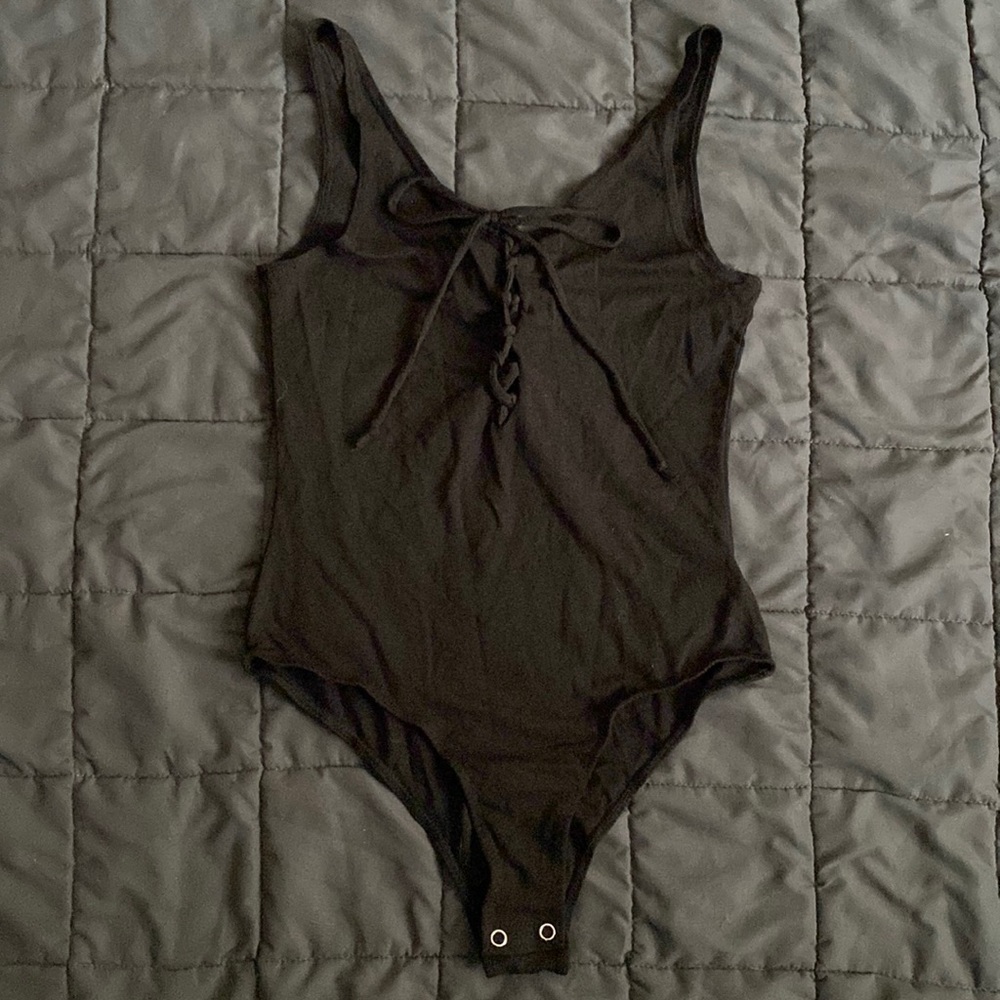 NWT - black bodysuit/onesie. Size medium. Never worn. Excellent condition